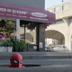 Spider-Man peeks his head out of a sewer manhole on an empty Brooklyn street.